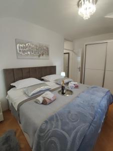 a bedroom with a large bed with two dolls on it at Apartman Oaza - Ploče, Croatia in Ploče