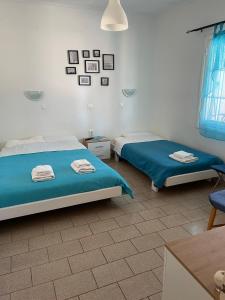 a bedroom with two beds and a table and a chair at Ta Ambelakia in Monemvasia