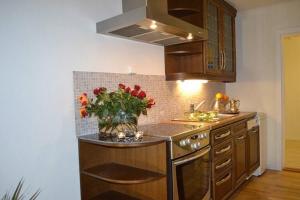 a kitchen with a counter with a vase of flowers at Lys og trivelig leilighet i Larvik in Larvik
