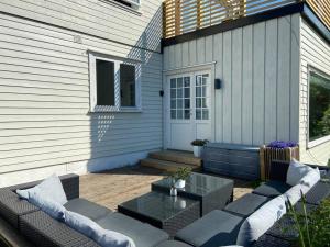 patio con divano e tavolo di fronte a una casa di Lys og trivelig leilighet i Larvik a Larvik