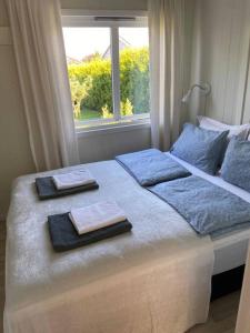 a bed with two towels on it with a window at Lys og trivelig leilighet i Larvik in Larvik