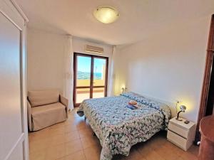 Mini Appartamenti Elba في لاكونا: غرفة نوم بسرير وكرسي ونافذة