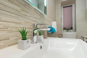 a bathroom sink with a faucet and two plants at Capitain*s House in Šibenik