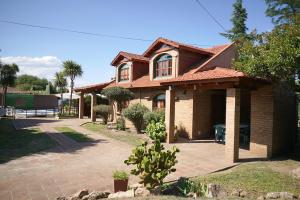 une maison en briques brunes avec une allée. dans l'établissement Cabañas La Aldea, à Villa Carlos Paz
