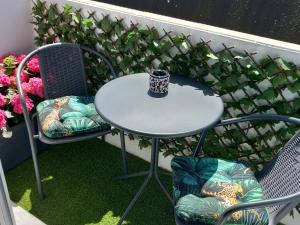 une table et des chaises sur un balcon avec une tasse dans l'établissement La petite Savane, à Ostende