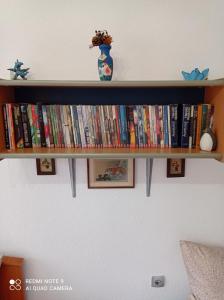 una estantería de madera con libros en la pared en Apartman Asja, en Visoko