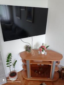 a flat screen tv hanging on a wall above a table at Apartman Asja in Visoko