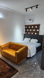 - une chambre avec un grand lit et un canapé en cuir dans l'établissement Keev Homes & Apartments Shortlet, à Port Harcourt