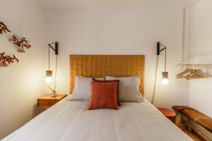 a bedroom with a white bed with a red pillow at Casa do Baloiço in Cortes do Meio