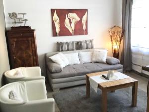 uma sala de estar com um sofá e duas cadeiras e uma mesa em Schwalbennest_ Silke Felix em Sierksdorf