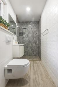 a white bathroom with a toilet and a shower at Harmony Apartments in Split