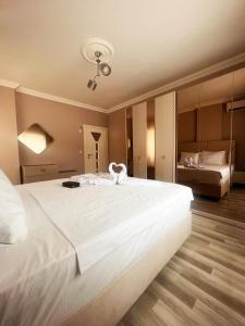 Seabird Suite Apart Hotel في طرابزون: سرير ابيض كبير عليه بجعه
