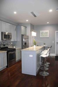 a kitchen with white cabinets and a island with bar stools at Upscale apartment Westside of Chicago in Chicago