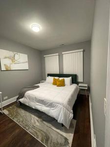 a bedroom with a large white bed with yellow pillows at Upscale apartment Westside of Chicago in Chicago