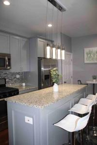a kitchen with a counter with white chairs and a island at Upscale apartment Westside of Chicago in Chicago