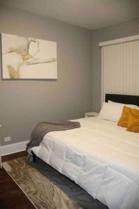 a bedroom with a large white bed and a painting at Upscale apartment Westside of Chicago in Chicago