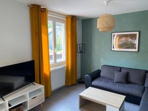 a living room with a couch and a table at Maison Village de La Verrerie in Cherbourg en Cotentin