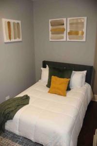 a large white bed with two yellow pillows on it at Upscale apartment Westside of Chicago in Chicago