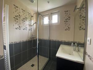 La salle de bains est pourvue d'une douche et d'un lavabo. dans l'établissement Maison Village de La Verrerie, à Cherbourg en Cotentin