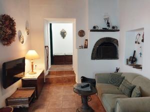 sala de estar con sofá y TV en Village Sense, Pergola & Unlimited View en Andros