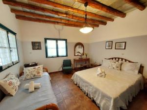 a bedroom with two beds and a table with a desk at Village Sense, Pergola & Unlimited View in Andros