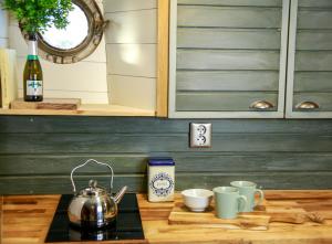 a kitchen counter with three cups and a tea kettle at Saimaa Experience in Savonlinna