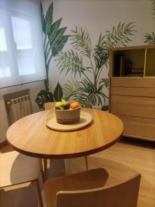 a wooden table with a bowl of fruit on it at Leon Riverside Flat in León