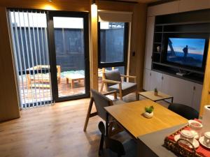 un salon avec une table à manger et une télévision dans l'établissement Vivero 5, departamento 5, à San Martín de los Andes