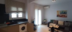 a kitchen and a living room with a couch at Kalamaria brand new 1 bedroom apartment in Thessaloniki