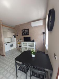 een woonkamer met een tafel en stoelen en een keuken bij I Limoni Bilocale in residence con piscina in Peschiera del Garda
