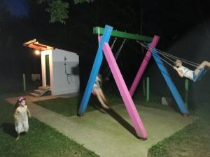 a group of people playing on a swing set at night at Kutak na Drini in Mali Zvornik