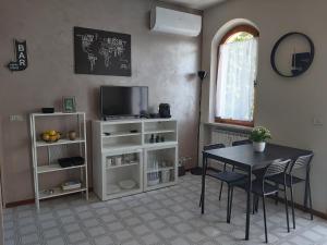uma sala de estar com uma mesa e uma televisão em I Limoni Bilocale in residence con piscina em Peschiera del Garda