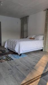 a bedroom with a white bed in a room at Nanisto Bush Lodge in Marloth Park