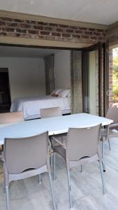 a table and chairs in a room with a bed at Nanisto Bush Lodge in Marloth Park