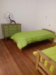 a bedroom with a green bed and a dresser at Bienvenidos al Sur in Buenos Aires