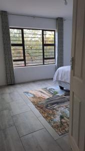 a bedroom with a bed and a large window at Nanisto Bush Lodge in Marloth Park
