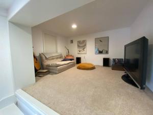 ein Wohnzimmer mit einem Sofa und einem Flachbild-TV in der Unterkunft Apartment with Private Deck & Mountain Views in Topanga