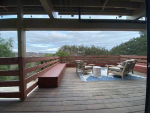 two chairs and a bench on a wooden deck at Modern Apartment w/ Private Deck & BEAUTIFUL VIEWS in Topanga