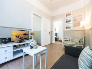 uma sala de estar com uma televisão e um sofá em Villa Amelia App 05 em Heringsdorf