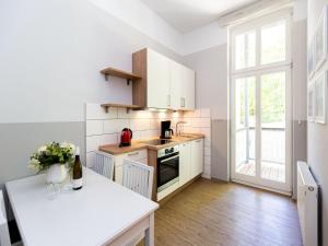 uma cozinha com armários brancos e um balcão branco em Villa Amelia App 05 em Heringsdorf