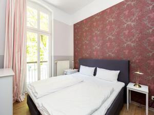 um quarto com uma cama grande e uma parede vermelha em Villa Amelia App 05 em Heringsdorf