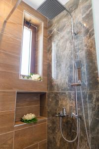 a bathroom with a shower with a glass door at ODYSSEA Top View & Hot Jacuzzi Front Beach in Kremasti