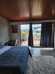 a bedroom with a bed and a large window at Los Portones de Ataco in Concepción de Ataco
