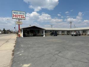 un estacionamiento vacío frente a un motel en Fossil Butte Motel, en Kemmerer