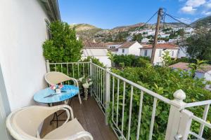 a balcony with a table and chairs and a view at Livin Hydra Private Collection Suite 2 in Hydra