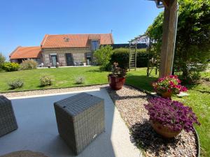 a patio with a bench and flowers in a yard at Entre Honfleur et Etretat in Octeville-sur-Mer