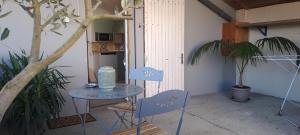 uma mesa e duas cadeiras com uma garrafa de água em Appartement 35m2 en RDC avec terrasse em Poueyferré