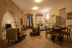 ein Wohnzimmer mit einem Tisch und Stühlen sowie ein Schlafzimmer in der Unterkunft La Chiocciola Assisi in Assisi