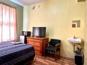 a hotel room with a bed and a tv and a chair at Entella Hotel in San Francisco