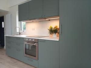 a kitchen with gray cabinets and a stove top oven at The Cottage - Fairwinds in Doolin +10 photos